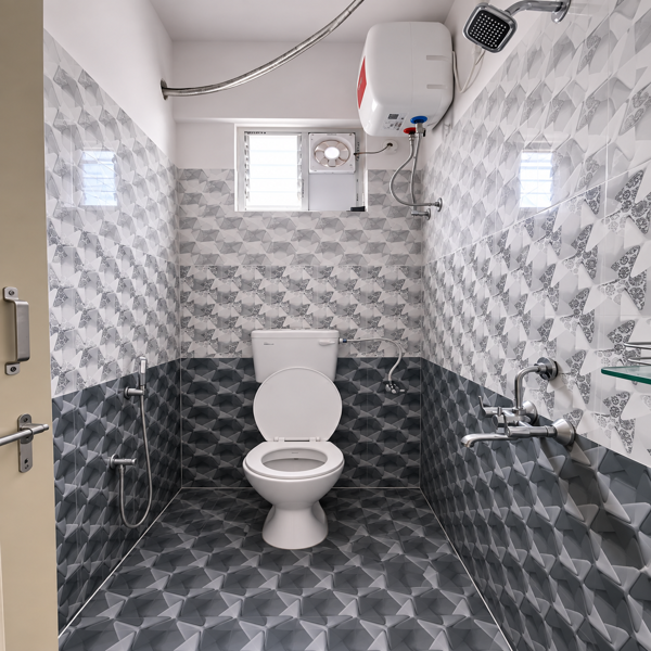 Modern bathroom, contemporary bathroom, luxury bathroom, stylish bathroom, clean bathroom, compact bathroom, toilet, western toilet, ceramic toilet, bathroom fixtures, wall mounted shower, shower head, water heater, electric geyser, wash basin, bathroom sink, chrome faucet, handheld bidet, health faucet, glass shelf, ventilation window, exhaust fan, patterned tiles, geometric tiles, grey tiles, white tiles, dark grey tiles, textured walls, tiled floor, marble effect, modern interiors, residential bathroom, home bathroom, bathroom design, interior design, sanitaryware, plumbing fixtures, bathroom accessories, minimalist bathroom, functional bathroom, bright bathroom, clean tiles, modern home, apartment bathroom, Indian bathroom, contemporary decor, utility space, indoor plumbing, sleek fixtures.
